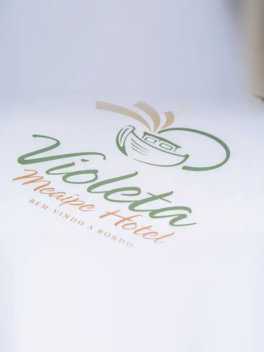 Logo do Violeta Meaípe Hotel, com o barco e a frase "Bem-vindo a bordo", impressa em tecido branco